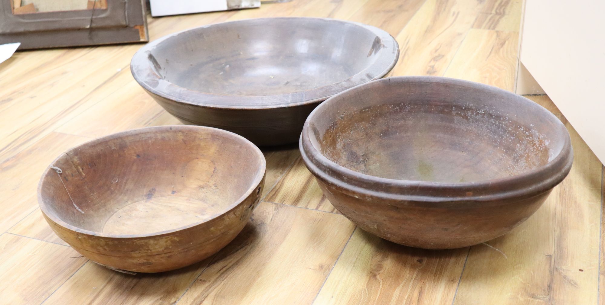 Three large treen bowls, largest diameter 47cm